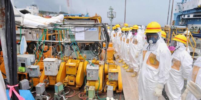 Des travailleurs de Fukushima, chargés de contrôler le démantèlement de la centrale, inspectent la construction de barrières censées empêcher l'écoulement d'eau contaminée dans l'océan. 