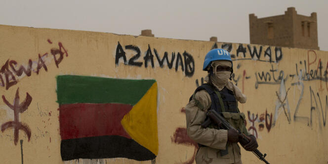 Un casque bleu à Kidal, au Mali, devant un graffiti de soutien à l'Etat indépendant de l'Azawad, le 28 juillet. 