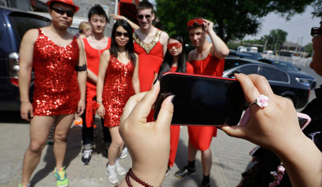 A woman uses her Samsung mobile phone to take a picture before a Red Dress run event in Beijing in this May 12, 2013 file photo. Samsung, the South Korean giant, now has a 19 percent share of the $80 billion smartphone market in China, a market expected to surge to $117 billion by 2017, according to International Data Corp (IDC). That's 10 percentage points ahead of Apple, which has fallen to 5th in terms of China market share. Picture taken May 12, 2013. To match Insight story SAMSUNG-APPLE/CHINA REUTERS/Jason Lee/Files (CHINA - Tags: BUSINESS TELECOMS)