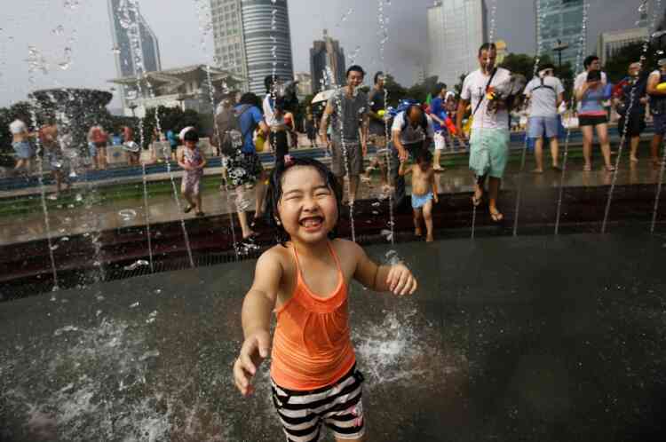 A girl participates in a water fight at People Square in Shanghai July 21, 2013. The temperature in Shanghai rose to 36 degrees Celsius (97 degrees Fahrenheit) on Sunday, reported local news.  REUTERS/Carlos Barria  (CHINA - Tags: SOCIETY ENVIRONMENT)