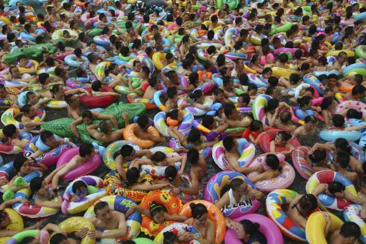 Visitors crowd an artificial wave pool at a tourist resort to escape the summer heat in Daying county of Suining, Sichuan province, July 27, 2013. Picture taken July 27, 2013. REUTERS/China Daily (CHINA - Tags: ENVIRONMENT TRAVEL SOCIETY TPX IMAGES OF THE DAY) CHINA OUT. NO COMMERCIAL OR EDITORIAL SALES IN CHINA