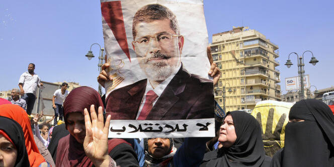 Des partisans des Frères musulmans manifestent au Caire le 30 août et brandissent le portrait de Mohamed Morsi.