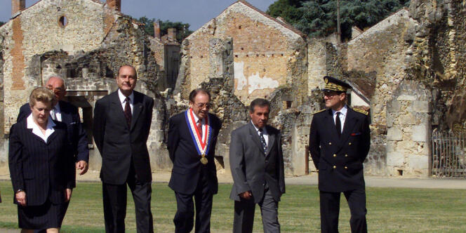 Jacques Chirac (3e G), accompagné de la ministre Catherine Trautmann (G), traverse, le 16 juillet 1999, ce village martyr avant de participer à l'inauguration du Centre de la Mémoire.