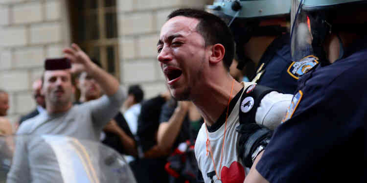 A participant in Occupy Wall Street protest is arrested by police during a rally to mark the one year anniversary of the movement in New York, September 17, 2012.  Police in New York on Monday arrested at least a dozen demonstrators marking the one-year anniversary of the Occupy Wall Street movement, witnesses said. At least eight people were taken into custody when they tried to block an entrance to Wall Street, representatives of the National Lawyers Guild at the scene, told AFP. Others were arrested when they started moving from Zuccotti Park toward Wall Street as police on horseback blocked side streets on horseback, according to an AFP reporter at the scene.  AFP PHOTO/Emmanuel Dunand
