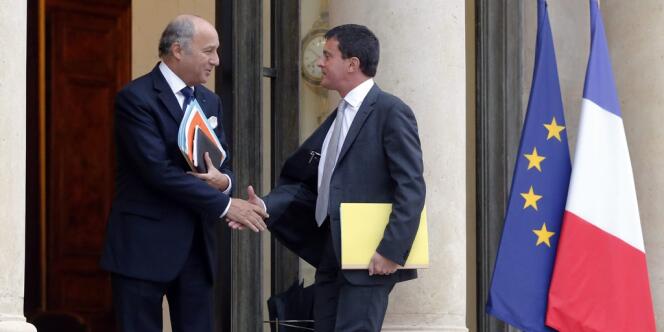 Le ministre des affaires étrangères Laurent Fabius et son homologue de l'intérieur Manuel Valls, à leur arrivée au conseil de défense restreint, à l'Elysée, mercredi matin. 