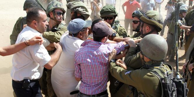 Des soldats israéliens contiennent des Palestiniens aux abords d'un camion de vivres, vendredi, en Cisjordanie. 