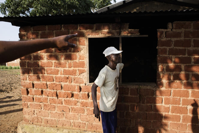 Albert Guillaume Sana Yanissi et Camille Mandaba (à gauche), un des chefs du quartier populaire de Boy-Rabé,  montrent les impacts de balles et de roquettes après l'attaque de leur maison par les forces de la Séléka.