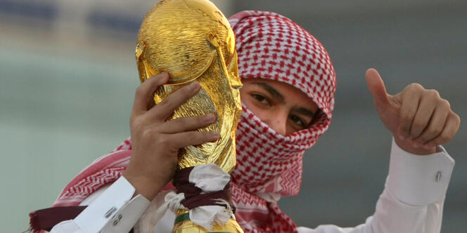 Un jeune Qatari brandit une copie de la Coupe du monde après l'annonce par la FIFA, en 2010, que cet Etat du Golfe accueillerait le Mondial de football 2022. 