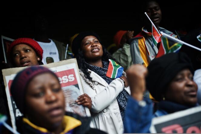Des femmes entonnent l'hymne national sud-africain en hommage à Nelson Mandela, dans le stade Orlando, à Soweto, mardi.