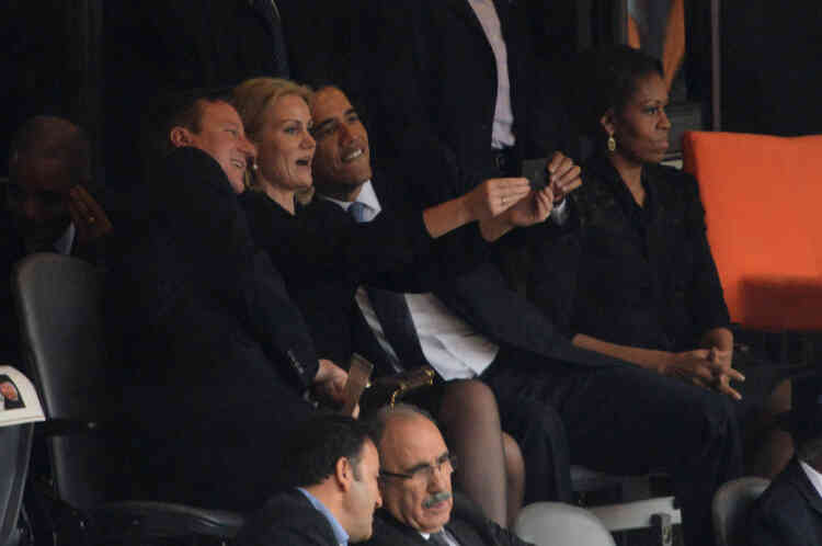 US President  Barack Obama (R) and British Prime Minister David Cameron pose for a picture with Denmark's Prime Minister Helle Thorning Schmidt (C) next to US First Lady Michelle Obama (R) during the memorial service of South African former president Nelson Mandela at the FNB Stadium (Soccer City) in Johannesburg on December 10, 2013. Mandela, the revered icon of the anti-apartheid struggle in South Africa and one of the towering political figures of the 20th century, died in Johannesburg on December 5 at age 95.   AFP PHOTO / ROBERTO SCHMIDT