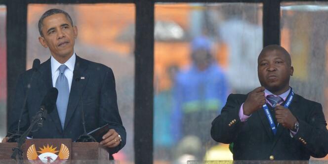 Le président américain Barack Obama prononce un discours à côté d'un interprète en langue des signes au cours de la cérémonie commémorative pour Nelson Mandela, à Johannesburg le 10 décembre.