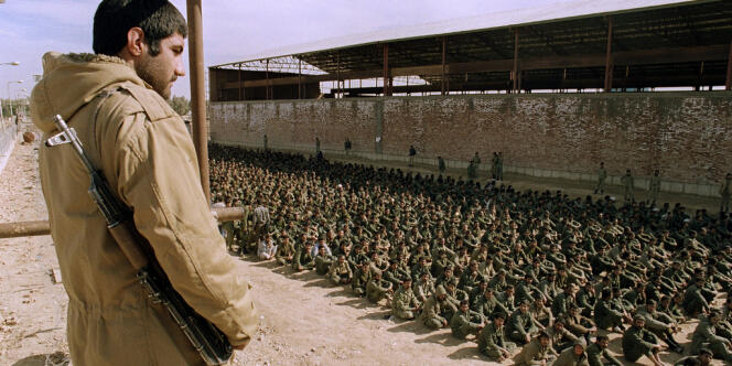 En janvier 1987, près d'Ahvaz (Iran), un soldat iranien surveille des prisonniers irakiens.
