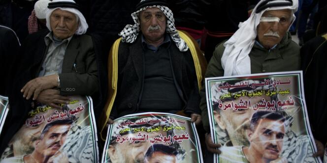 Des Palestiniens portent le portrait d'un des prisonniers libéré, Na'em Al-Shawamreh.