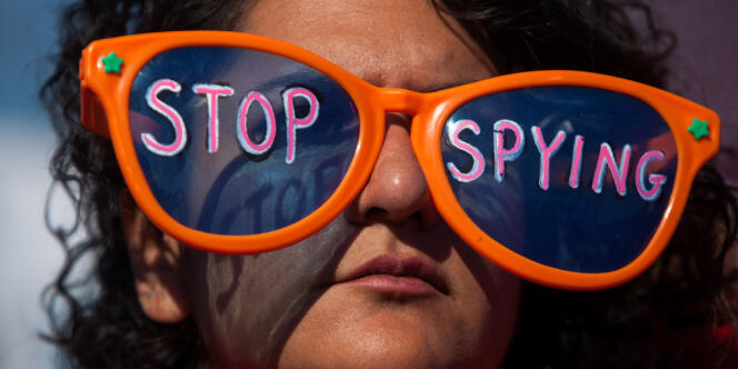 Lors d'une manifestation organisée à Washington contre la surveillance abusive de la NSA en octobre 2013, une femme porte des lunettes sur lesquelles on peut lire : « Arrêtez l'espionnage ».