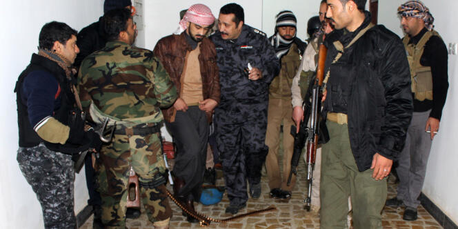Mohammed Khamis Abou Risha, commandant d'une milice tribale, avec un policier, dans le quartier de Malaab à Ramadi, le 10 janvier. 