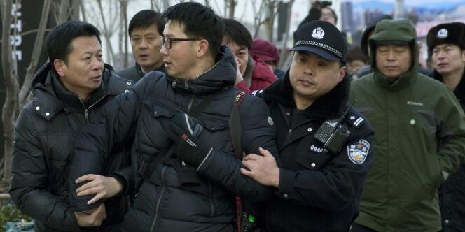 Un photographe qui prenait en photo l'avocat de Xu Zhiyong, Zhang Qingfang, parlant aux médias devant la cour de justice à Pékin le 26 janvier a été emmené par des policiers.