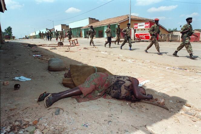 Des soldats du Front patriotique rwandais, devant le cadavre d'une femme tuée par une milice pro-gouvernementale, en 1994.