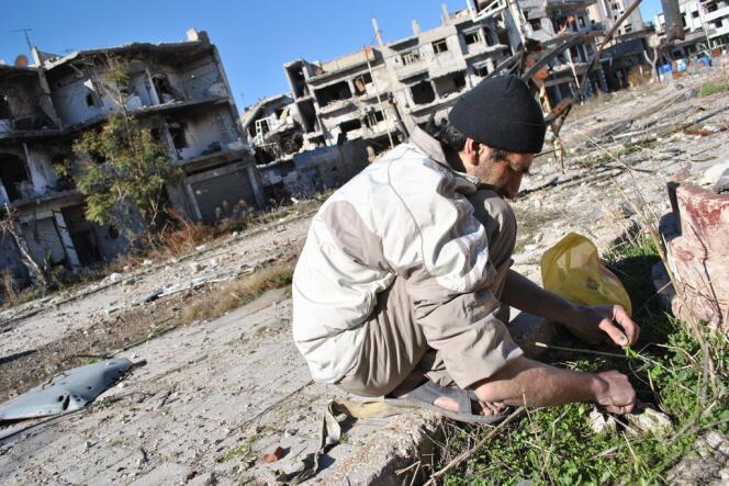 Un homme cherche des herbes pour se nourrir, en février à Homs.