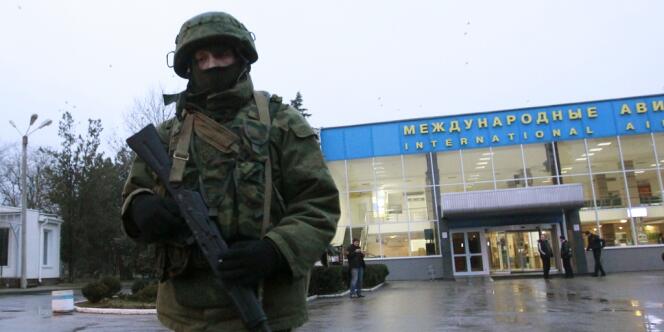 Un homme armé patrouille devant l'aéroport de Simferopol, le 28 février en Crimée.