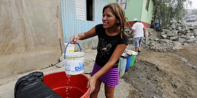 Le 27 février, dans les faubourgs de Lima, une habitante s'approvisionne en eau dans un quartier qui ne dispose pas encore d'un réseau d'eau potable. 