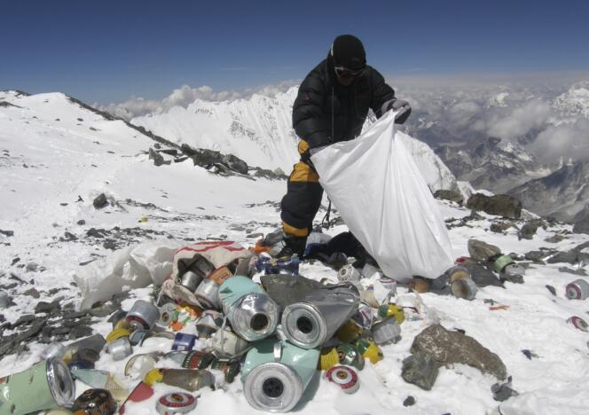 Un sherpa népalais ramasse des détritus laissés par les alpinistes, sur le Mont Everest, à 8 000 mètres d'altitude.