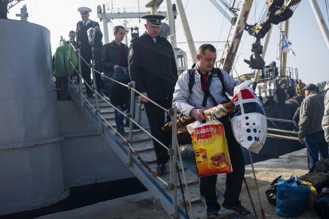 Des marins et officiers ukrainiens quittent la corvette «Khmelnitsky», saisie par les forces prorusses, jeudi 20 mars, à Sébastopol.
