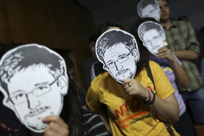 Manifestations contre les écoutes de la NSA en 2013. Des contestataires brandissent devant leur visage le portrait d'Edward Snowden, ancien analyste de l'Agence nationale de sécurité qui a révélé l'ampleur internationale de la surveillanc américaine.
