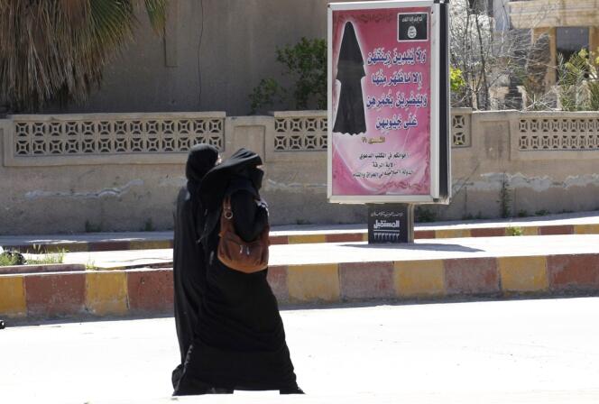 A Rakka, en Syrie, fief du groupe djihadiste Da’ech, un panneau portant des versets du Coran enjoint aux femmes de porter le niqab (voile islamique).