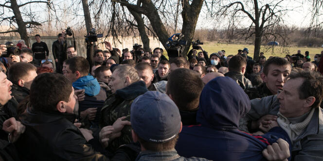 Devant l’aérodrome de Kramatorsk, le général Vassili Kroutov (tête nue au centre) est molesté par des habitants, mardi 15 avril.
