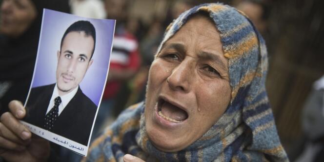 Une femme montre le portrait d'un condamné à mort en Egypte.