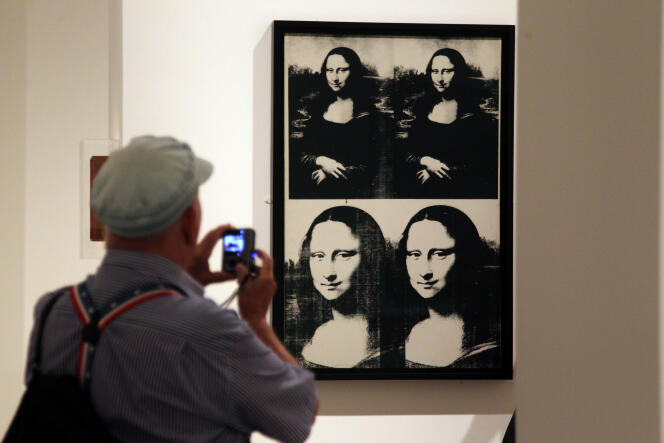 Un visiteur photographie une œuvre d'Andy Warhol représentant la Jaconde, au Metropolitan Museum of Art de New York, en septembre 2012.