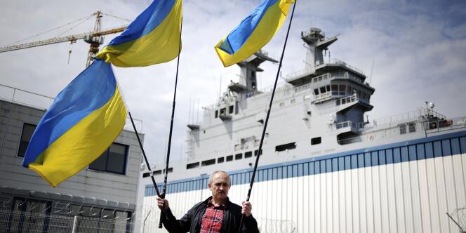 A Saint-Nazaire, le 1er juin, un manifestant brandit des drapeaux ukrainiens devant le « Vladivostok », 
un navire de guerre de type Mistral construit en France et destiné à être vendu à la Russie. 