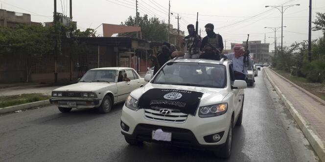 Des djihadistes de l'EIIL dans les rues de Mossoul, à bord de véhicules appartenant aux forces de sécurité irakiennes.