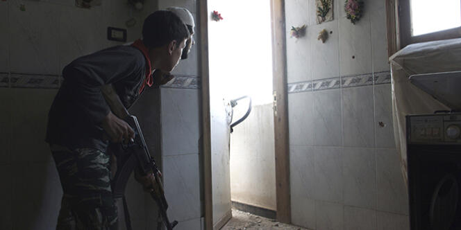Un jeune combattant de la brigade de l'Armée syrienne libre, âgé de 14 ans, prend position à l'intérieur d'une maison à Deir Ez-Zor, dans l'est de la Syrie, en juillet 2013.
