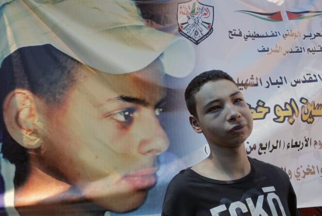 Tareq Abou Khdeir (à droite), jeune Américain d’origine palestinienne, dimanche 6 juillet à Chouafat. Il aurait été victime d’un passage à tabac par la police israélienne. Son cousin Mohammed, représenté sur la banderole, a été enlevé le 2 juillet avant d’être brûlé vif.
