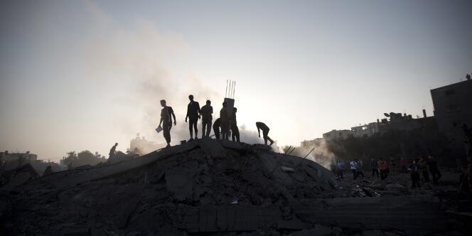 Des palestiniens inspectent des maisons détruites par un tir de l'armée israélienne à Gaza, le 8 août.