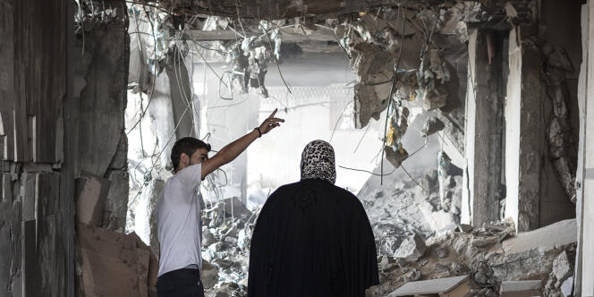 Des Palestiniens regardent les destructions d'un immeuble de Gaza, le 23 juillet.