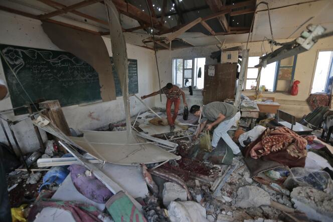 Des Palestiniens recueillent des restes des corps des 16 enfants réfugiés dans l'école de l'ONU de Jabalia et tués, mercredi 30 juillet 2014, par des tirs de chars israéliens. 