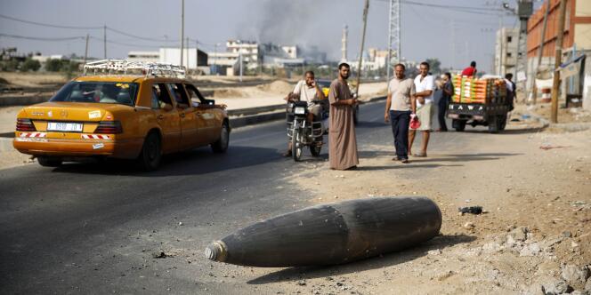 Des habitants de la bande de Gaza inspectent, vendredi 1er août, à Deir Al-Balah, une bombe de l’armée israélienne qui n’a pas explosé.