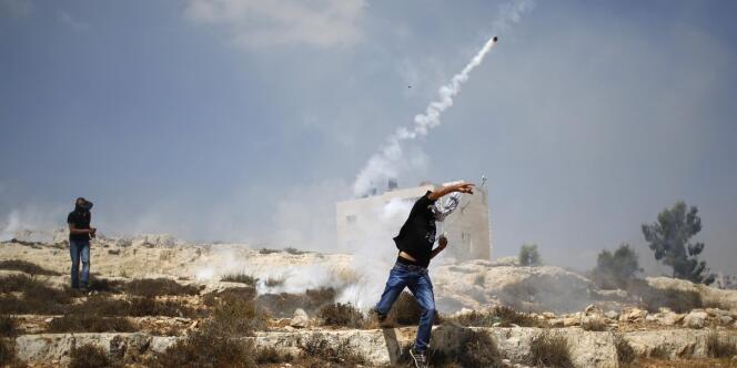 Un Palestinien renvoie une grenade de gaz lacrymogène à Rafah, le 2 août 2014. 