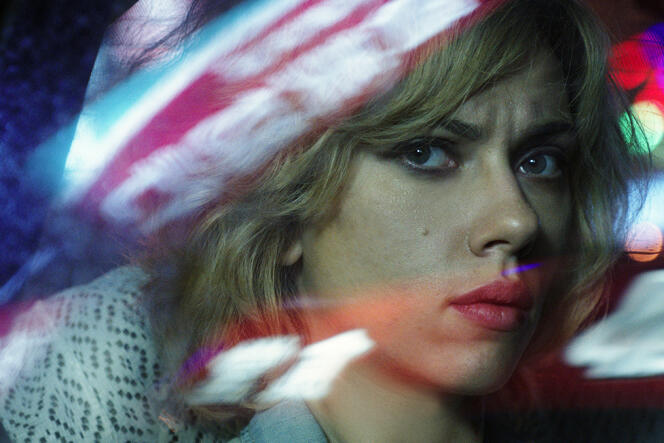Lucy (Scarlett Johansson) passe de la drogue pour un gang.