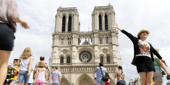 Des touristes devant la cathédrale Notre-Dame, à Paris, en août.