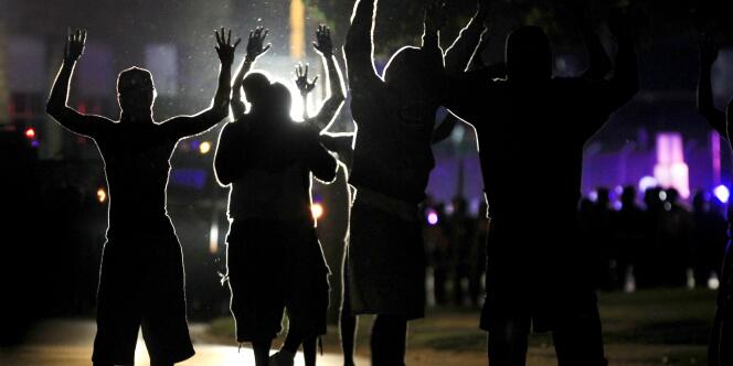 Des émeutiers font face aux policiers à Ferguson le 11 août, une petite ville du Missouri sous tension depuis qu'un adolescent noir a été abattu par un policier de la ville.