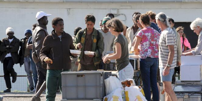 Les membres d'une ONG distribuant de la nourriture aux migrants à Calais, le 5 août.
