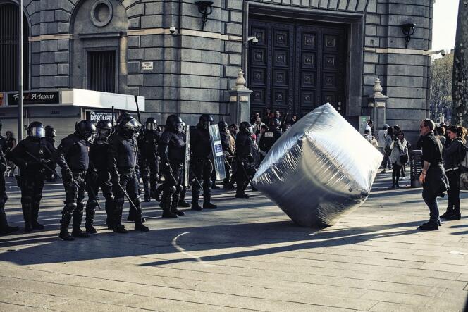 Pavé géant gonflable brandi face à la police à  Barcelone, en 2012 : exemple d'objet ayant vocation à contester l'ordre établi que présente l'exposition du Victoria  and Albert Museum, conçue notamment par Gavin Grindon.