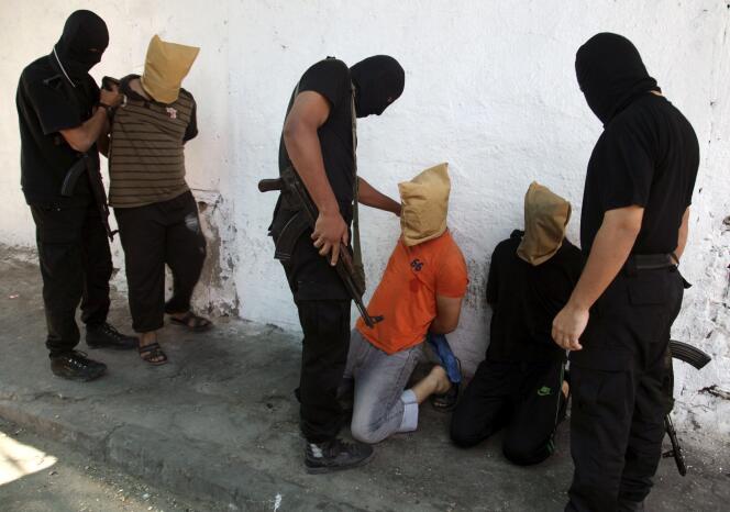 Des combattants du Hamas s'apprêtent à exécuter en public des Palestiniens accusés de collaboration avec Israël, vendredi 22 août à Gaza.  