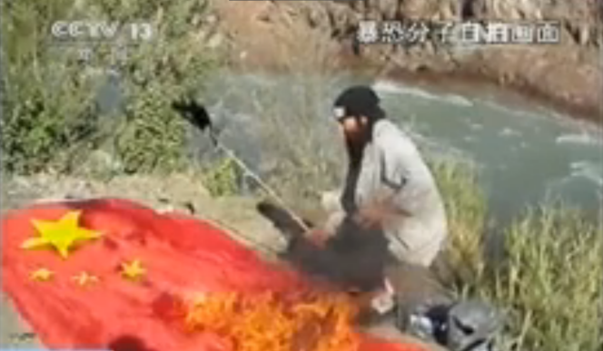 Capture d'écran de la télévision chinoise qui a diffusée un extrait d'une vidéo montrant l'un des auteurs de l'attentat de Tiananmen entrain de brûler le drapeau chinois. 