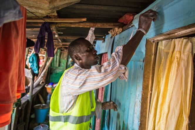 Un volontaire marque à la craie une maison dans laquelle il s'est rendu, le 20 septembre à Freetown.