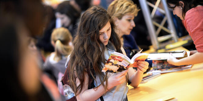 Une jeune fille lit un livre au Salon du livre de Paris, le 21 mars.