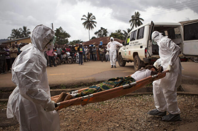Le 24 septembre 2014, à Kenema, en Sierra Leone, des personnels de santé évacuent un habitant présumé atteint par le virus.